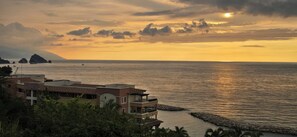 A coastal view with a building overlooking the sea, featuring a balcony and a rocky shoreline. - Oceanfront Studio in a 5 star Garza Blanca Resort, Puerto Vallarta, Mexico (Puerto Vallarta)