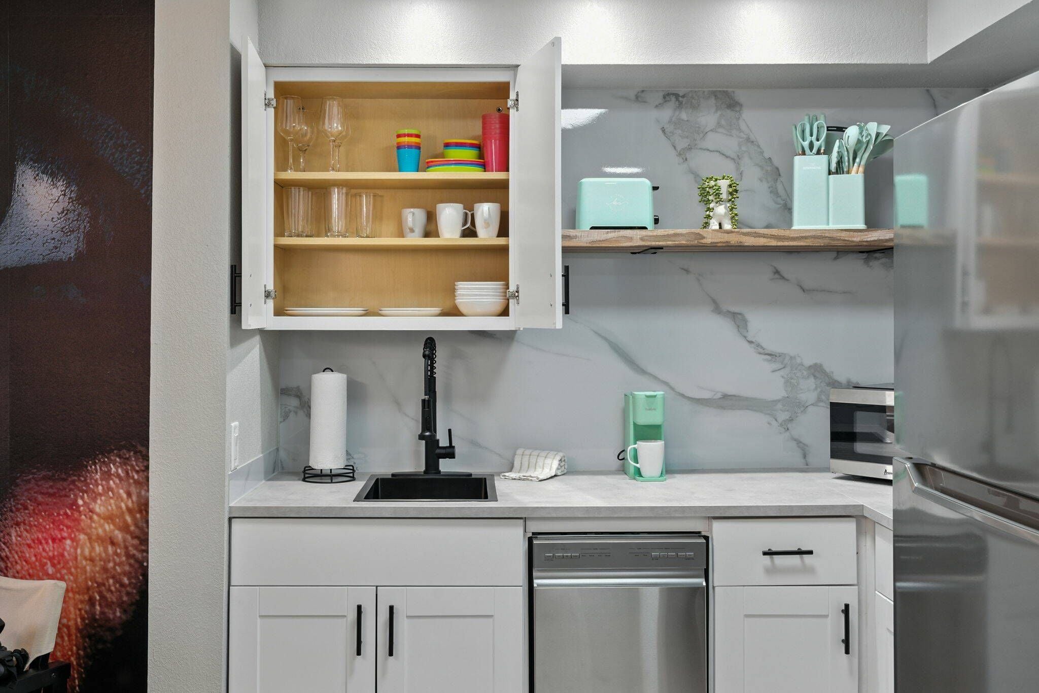 A modern kitchen with a built-in dishwasher, a coffee machine, and a microwave.