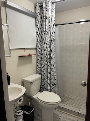 A bathroom with a toilet, sink, and shower curtain. - Cozy 2BR in Carolina 12min to Beach & Airport Near All (Carolina)