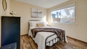 A bedroom with a bed, a dresser, a window with a view, and wall art. - Modern 4BR Sparks Retreat Hot Tub near Reno/Tahoe (Sparks)