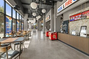 Ein Restaurantinneres mit Tischen, Stühlen, einer Theke und Speisekarten.