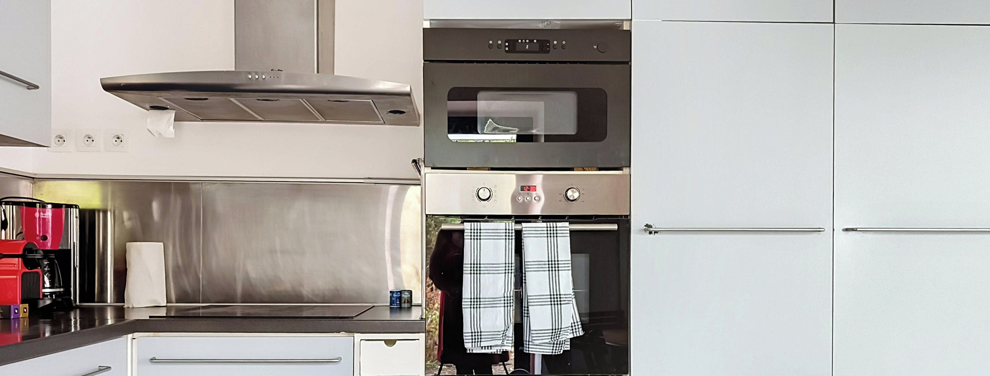 A modern kitchen with stainless steel appliances, a built-in oven, and a microwave.