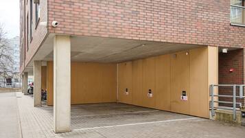 A parking garage with concrete pillars and a brick wall.