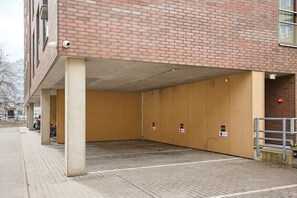 Un parking avec des piliers en béton et un mur en briques.