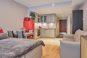 Ein kompakter Wohnraum mit Küchenzeile, Essbereich und Schlafzimmer.