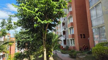 Un edificio residencial de varios pisos con balcones, fachada de ladrillo y un cartel con el número 'T3'.