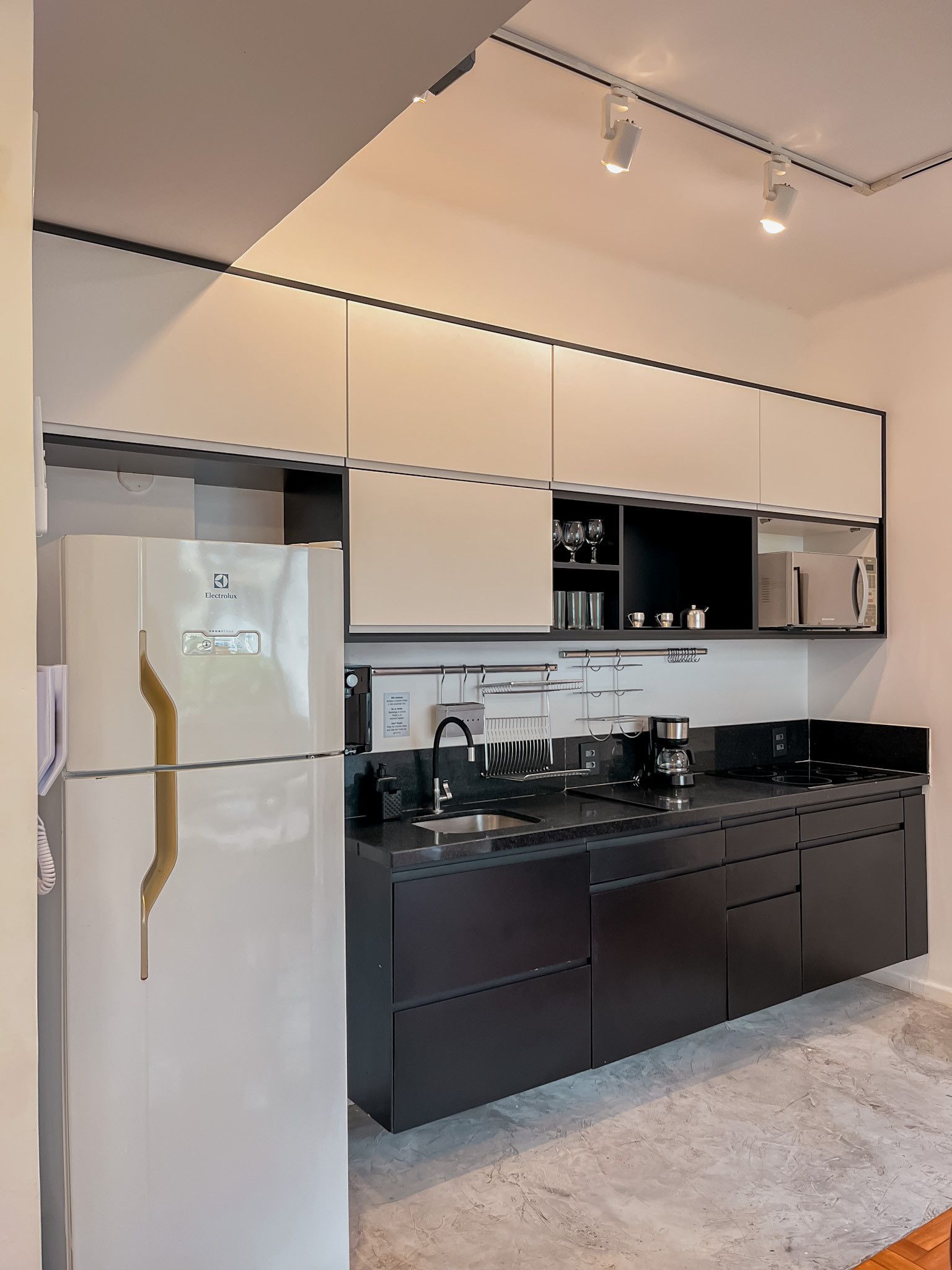 A modern kitchen with a built-in refrigerator, a microwave, and a coffee maker.