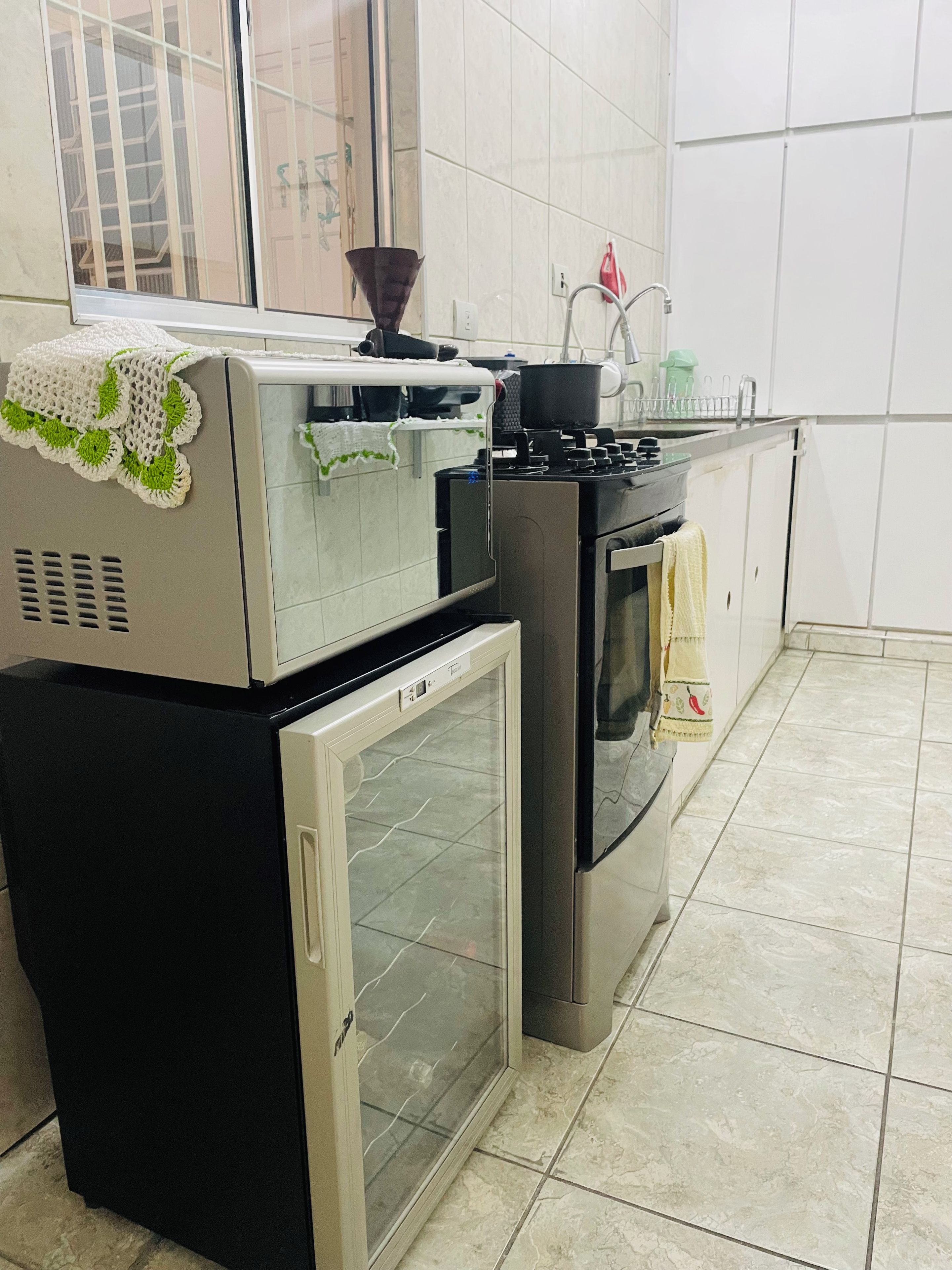 Cozinha equipada com frigorífico, forno e micro-ondas.