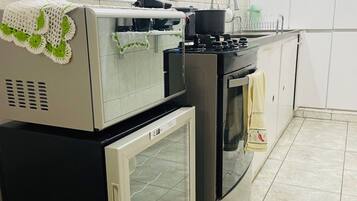 Cozinha equipada com frigorífico, forno e micro-ondas.