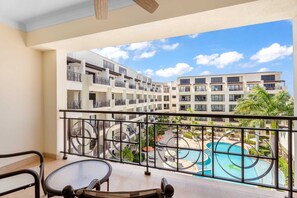 A balcony with a view of a swimming pool and a multi-story building with balconies. - PC404 - Pool View - 1 BR Perfect  for a couple - Close to Palm Beach - 1BR (Palm Beach)