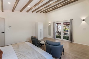 A bedroom with a bed, a desk, a chair, and a wardrobe. There is a sliding door leading to an outdoor area with a table and chairs. - PB98B-3 - Private Villa with pool - Close to Palm Beach (Palm Beach)