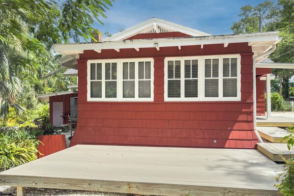 A red building with a white window frame and a small porch.