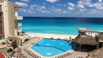 A resort with a pool, beach, and ocean view.