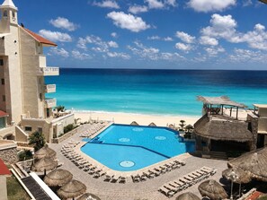 Um resort com piscina, praia e vista para o oceano.