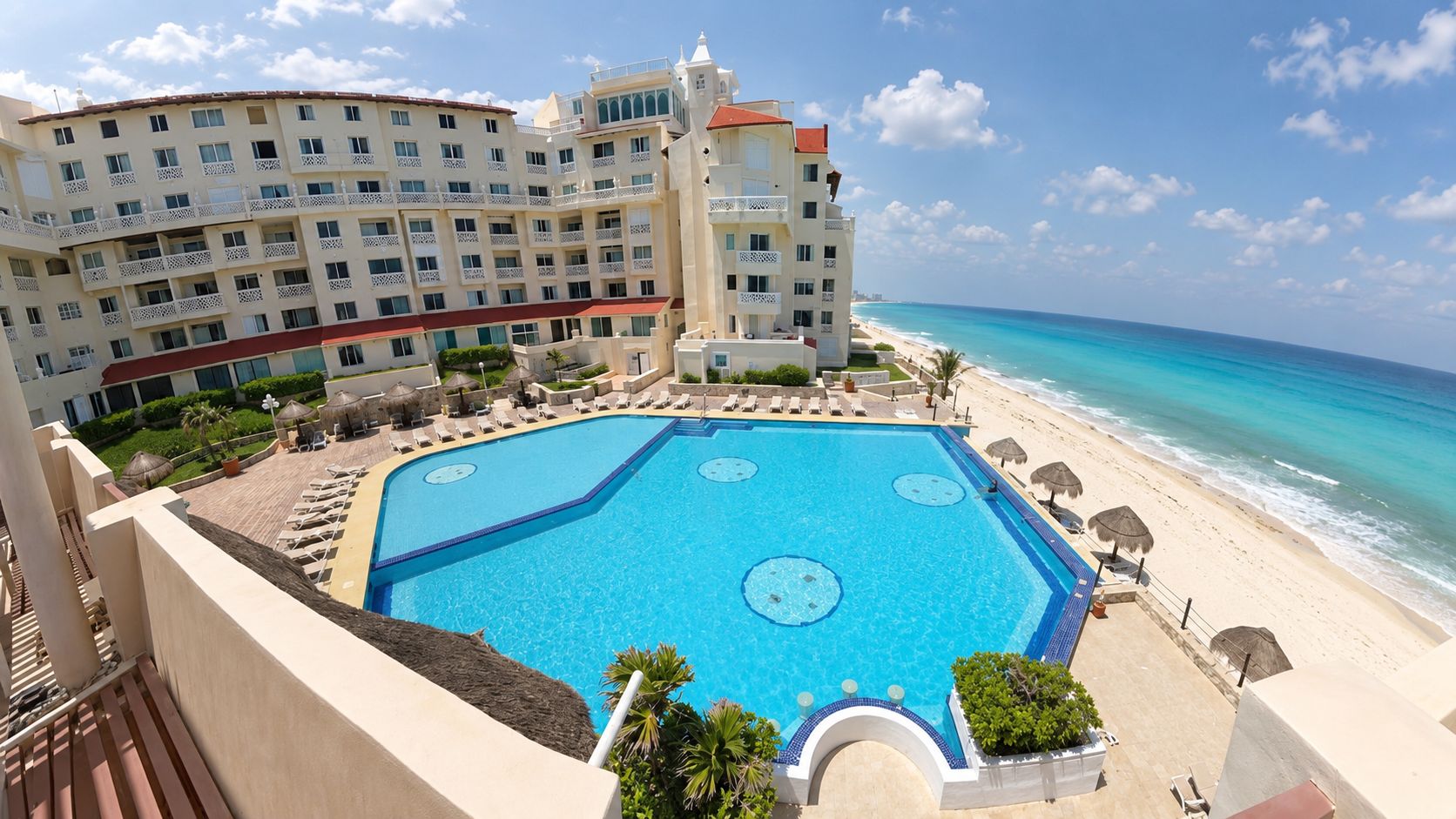 Un hôtel doté d’une grande piscine, d’un accès à la plage et offrant une vue sur l’océan.
