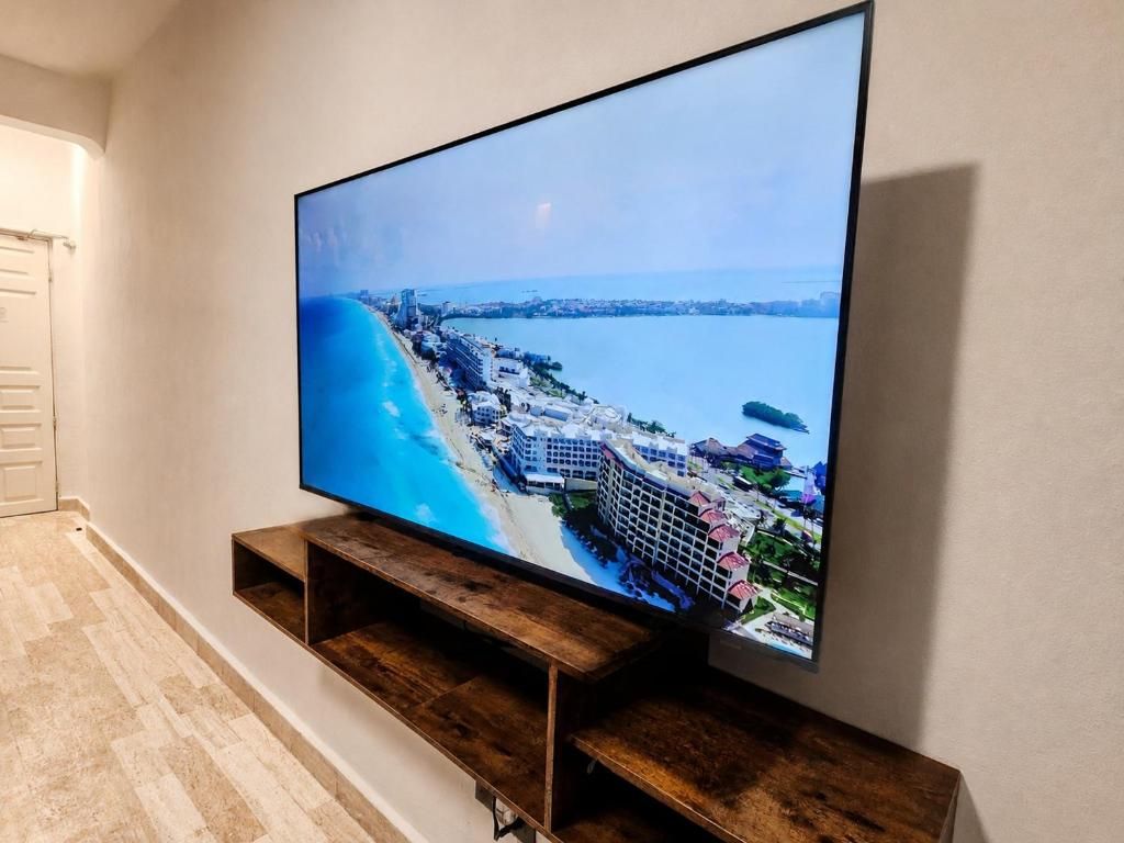 Uma televisão presa a um suporte de madeira encostada em uma parede.