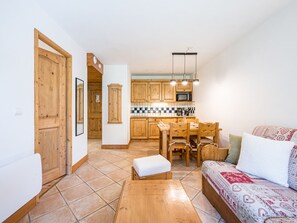 Ein kompakter Wohnraum mit Küchenzeile, Essbereich und einer Couch.
