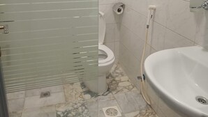 Un baño con inodoro, lavabo y mampara de cristal.