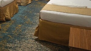 Una habitación de hotel con dos camas, una mesita y una silla.