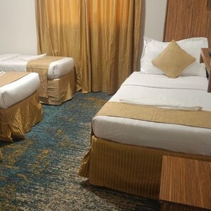 Ein Hotelzimmer mit zwei Betten, einem kleinen Tisch und einem Stuhl.