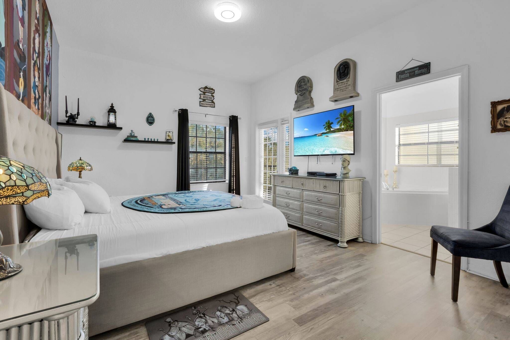 A bedroom with a bed, a TV, a dresser, and a chair.