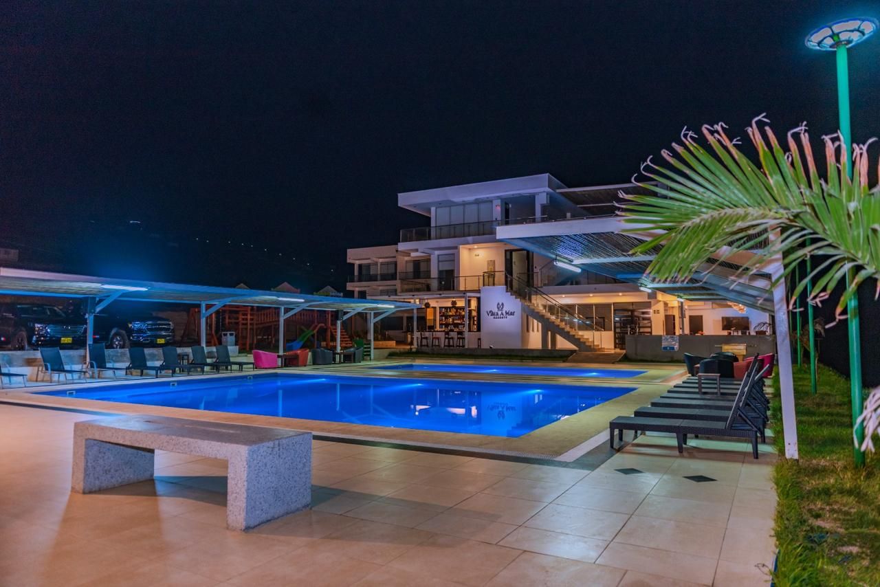 An outdoor swimming pool area with lounge chairs and a building with a staircase.