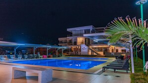 An outdoor swimming pool area with lounge chairs and a building with a staircase. - Vista a Mar (Aucallama)