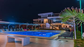 An outdoor swimming pool area with lounge chairs and a building with a staircase.