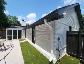 Asuinrakennuksessa on katettu patio, aidattu piha ja näkyvissä oleva savupiippu.