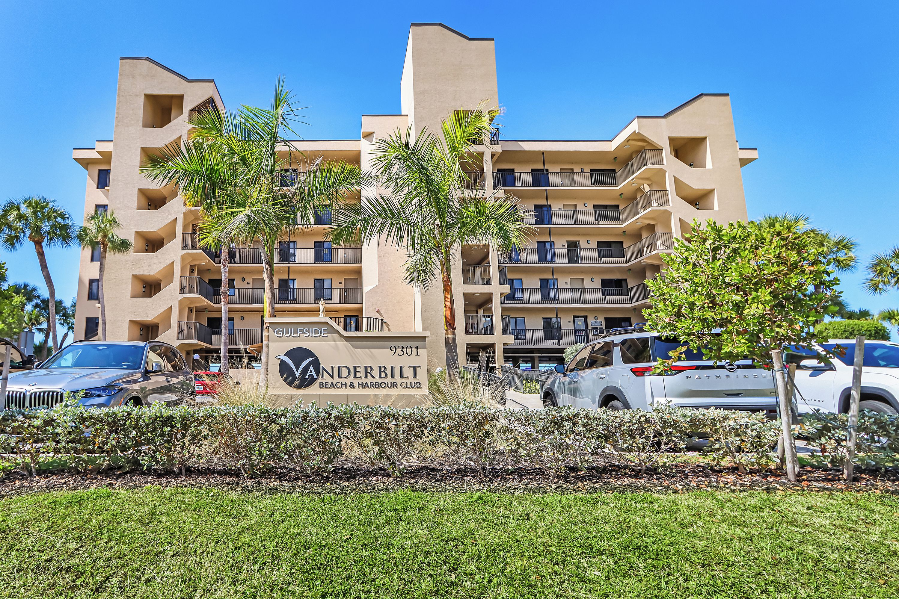 A multi-story hotel with a sign reading 'GULFSIDE VANDERBILT BEACH & HARBOUR CLUB' and the number '9301'.