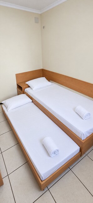 A room with two single beds, each with a wooden frame and white bedding. - No Melhor de Iracema ate 6 Pessoas (Fortaleza)