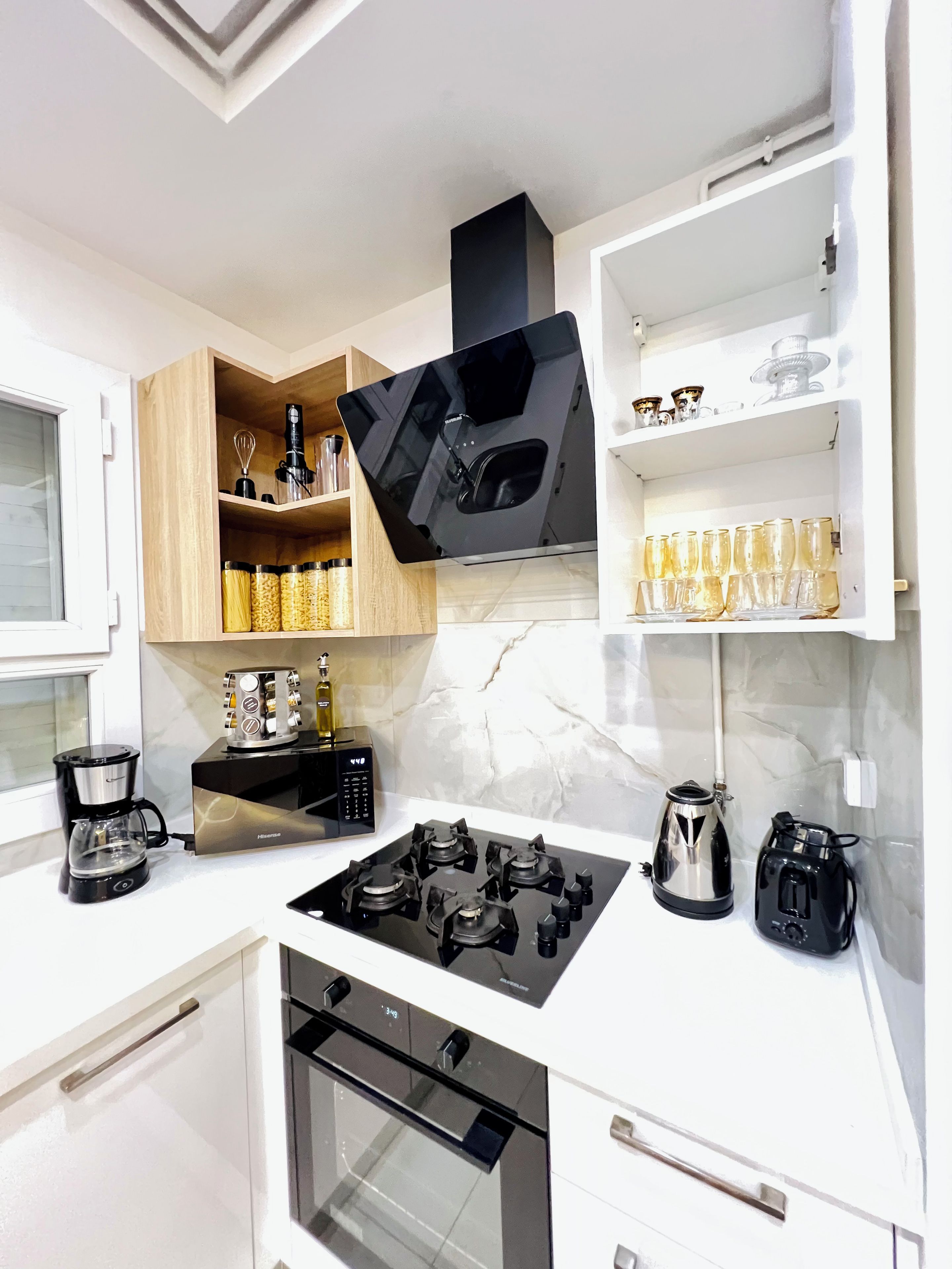 Una cucina moderna dotata di piano cottura, forno e macchina da caffè.