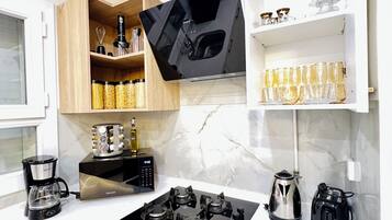 Una cucina moderna dotata di piano cottura, forno e macchina da caffè.