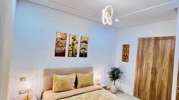 Una camera da letto con un letto, lampade sui comodini, un armadio in legno e decorazioni alle pareti.