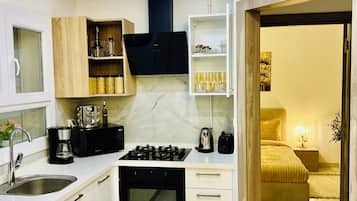 Een moderne keuken met een ingebouwde oven, een koffiezetapparaat en een zwarte afzuigkap.