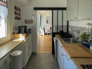 A compact kitchen with a wooden countertop, a sink, and a coffee machine. - Modern lodging near the beach - 4 guests (Saint-Hilaire-de-Riez)