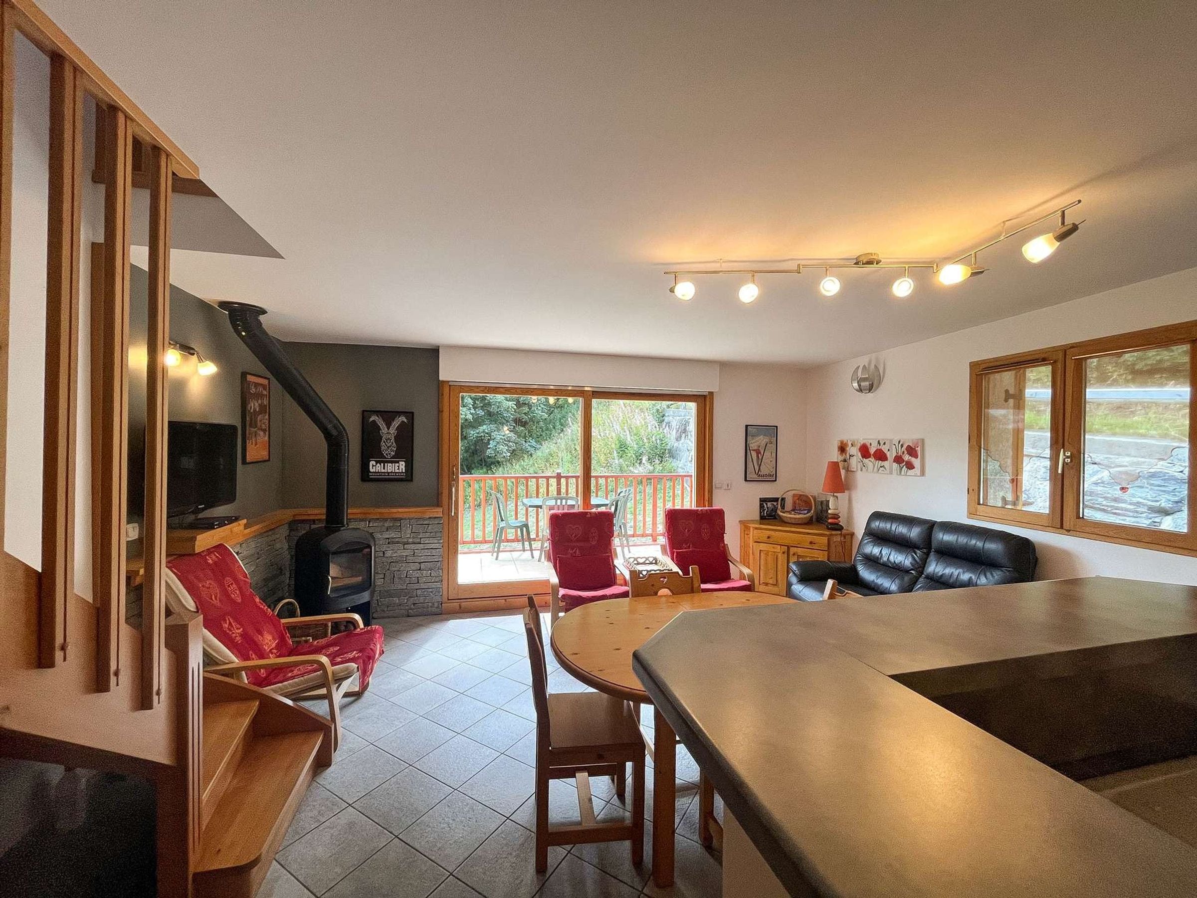 Un salon chaleureux avec une cheminée, des sièges confortables et une vue dégagée grâce à de grandes fenêtres.