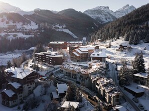 A snow-covered mountain resort with multiple buildings, including lodges and a ski lift. - Modern apartment, wheelchair access - 8 guests (Courchevel 1550)
