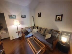 Ein gemütliches Wohnzimmer mit einer Couch, einem Couchtisch und einer Lampe.
