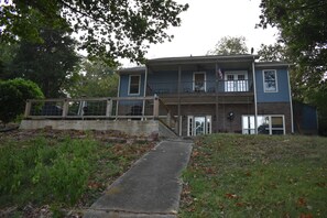 A two-story house with a front porch, a garage, and a fenced backyard.