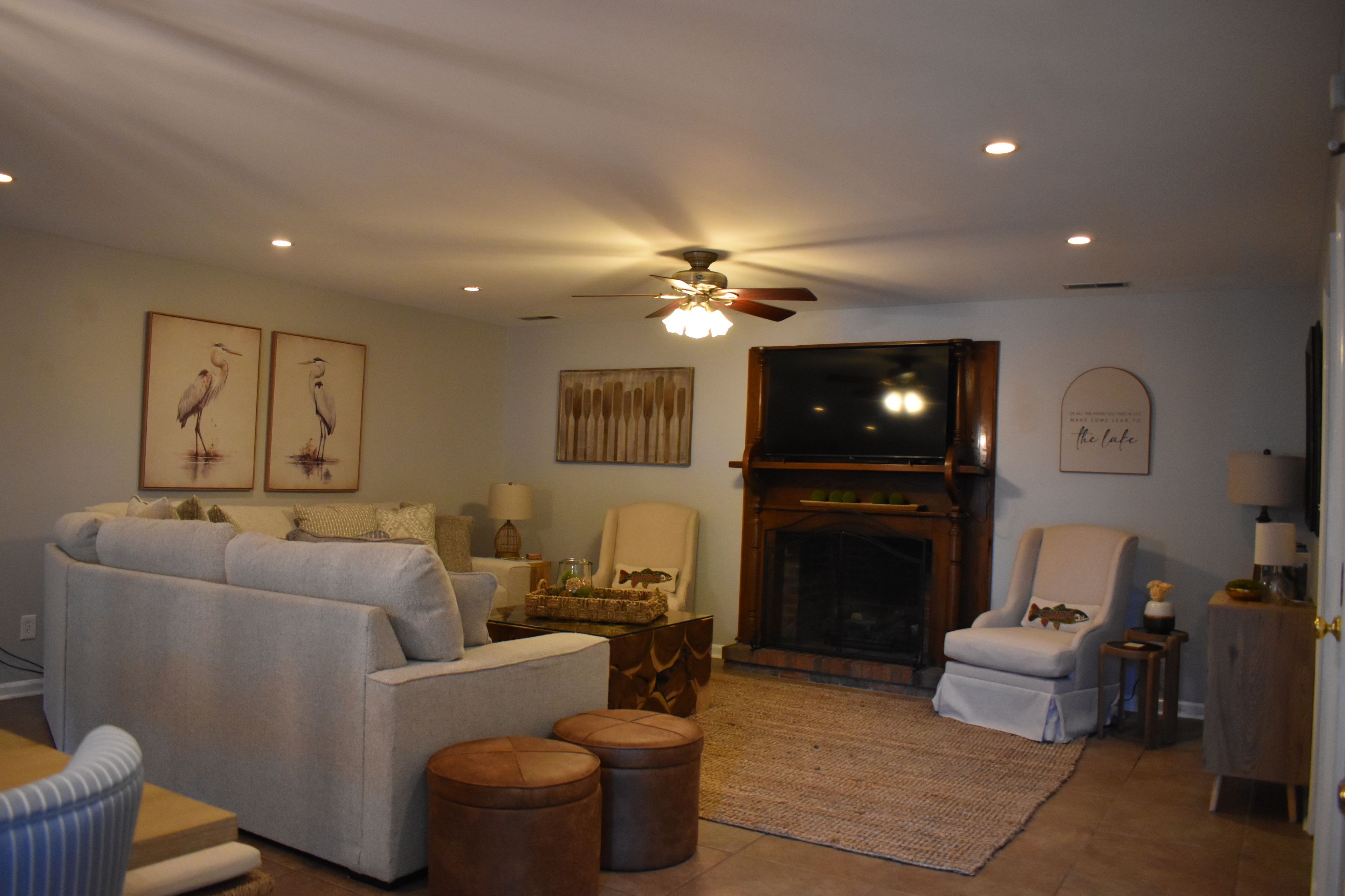 A living room with a fireplace, a ceiling fan, and a sofa.
