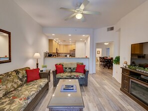 A living room with a sofa, coffee table, and a ceiling fan. - 2BR Condo Near Disney Resort Pool & Sauna (Kissimmee)
