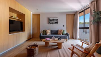 A modern living room with a sofa, coffee table, and a TV mounted on a wooden cabinet.