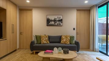 Una sala moderna con un sofá, una mesa de centro y un cuadro en la pared.