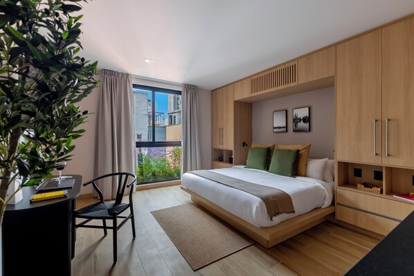 Un dormitorio moderno con cama, escritorio y silla.