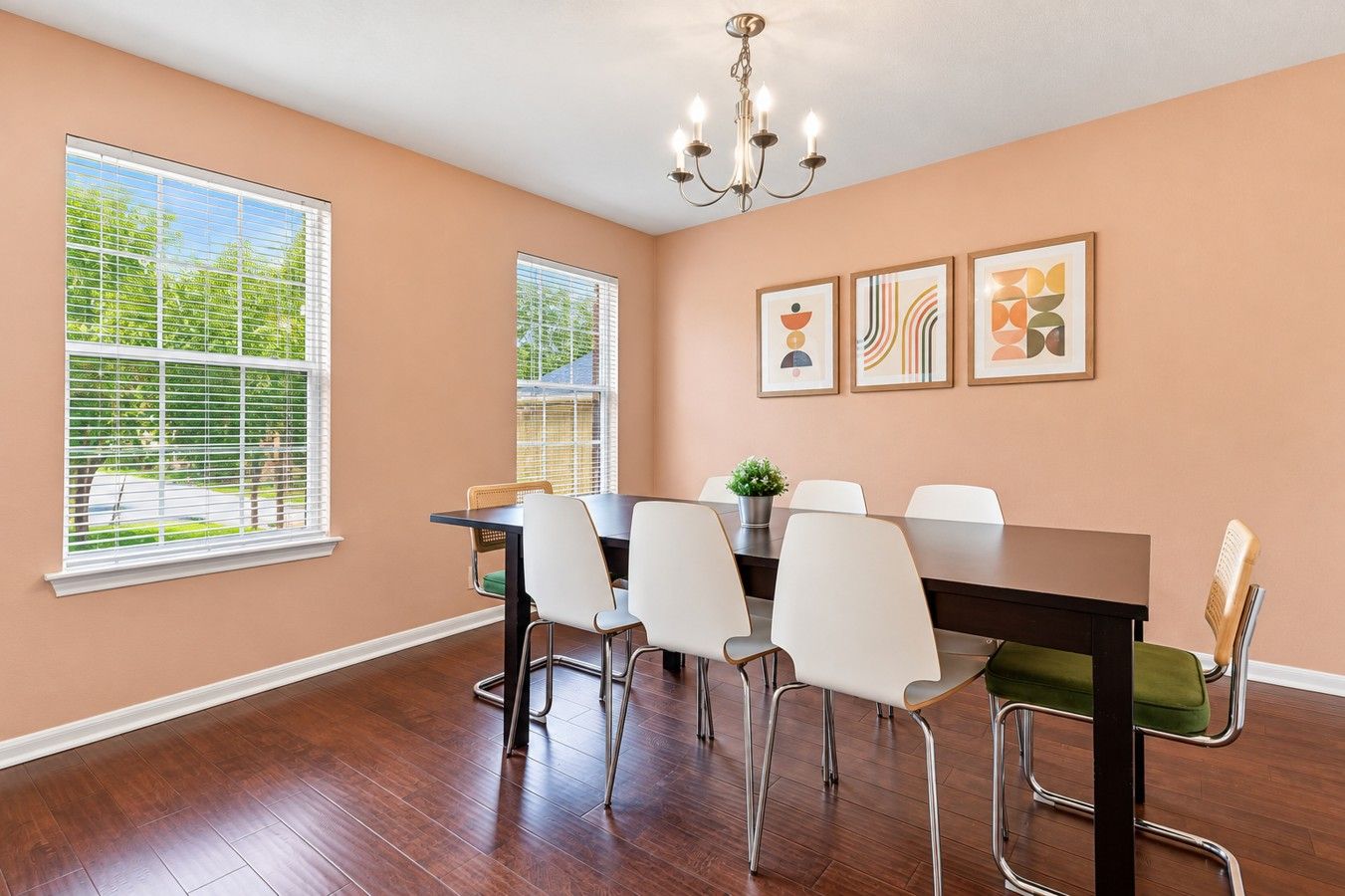 Une salle à manger avec une table, des chaises et des œuvres d’art accrochées au mur.