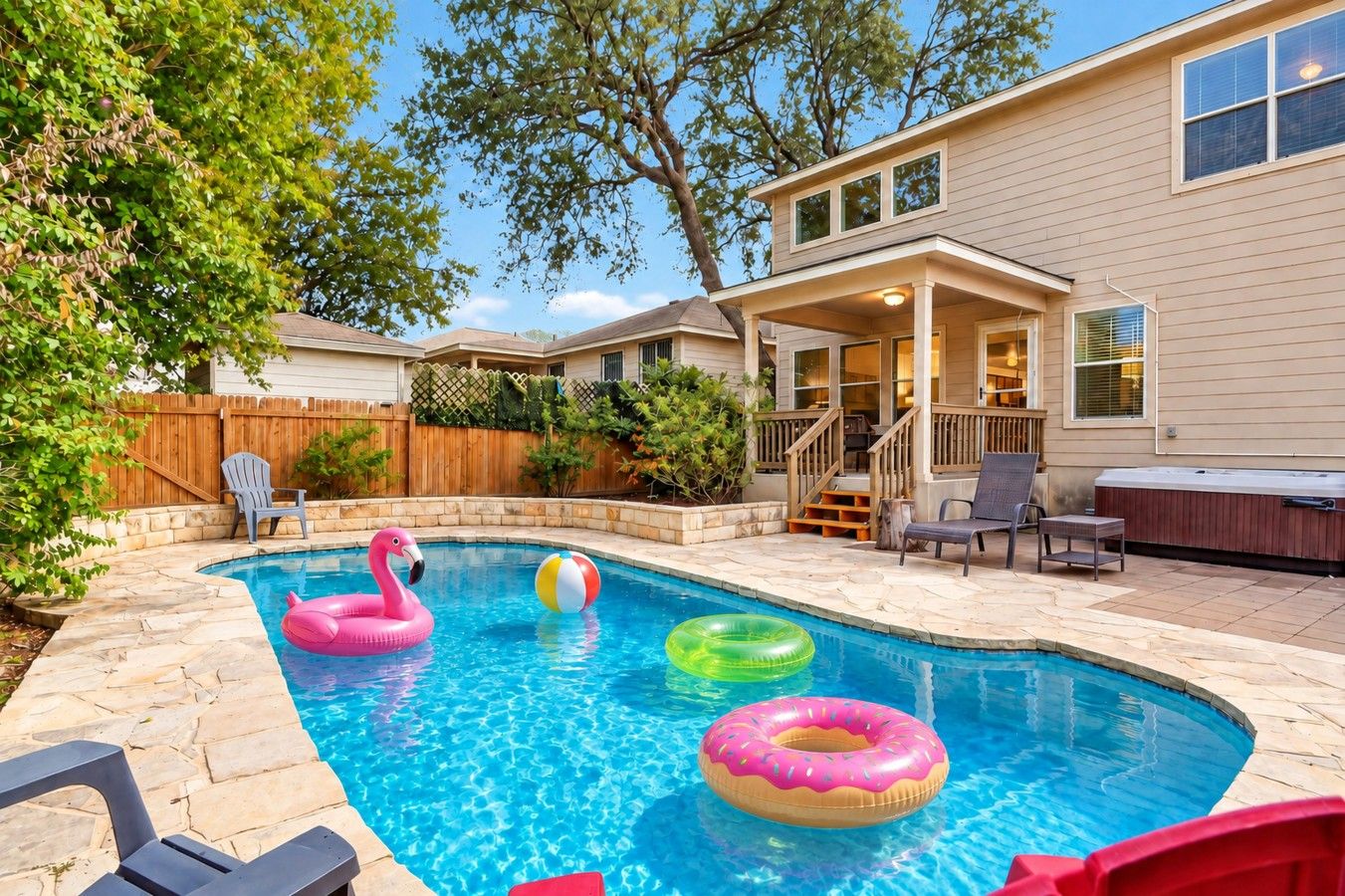 Ein Garten mit Pool, Schwimmspielzeug und Gartenmöbeln.
