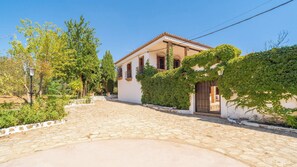 A white building with a tiled roof, a stone pathway, and greenery. - Heredad La Encarnación Ronda by Ruralidays (Málaga)
