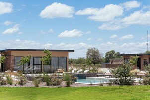 Un edificio moderno con piscina y zona de estar al aire libre.