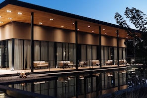 Un edificio moderno con piscina, ventanas amplias y zona de estar al aire libre.